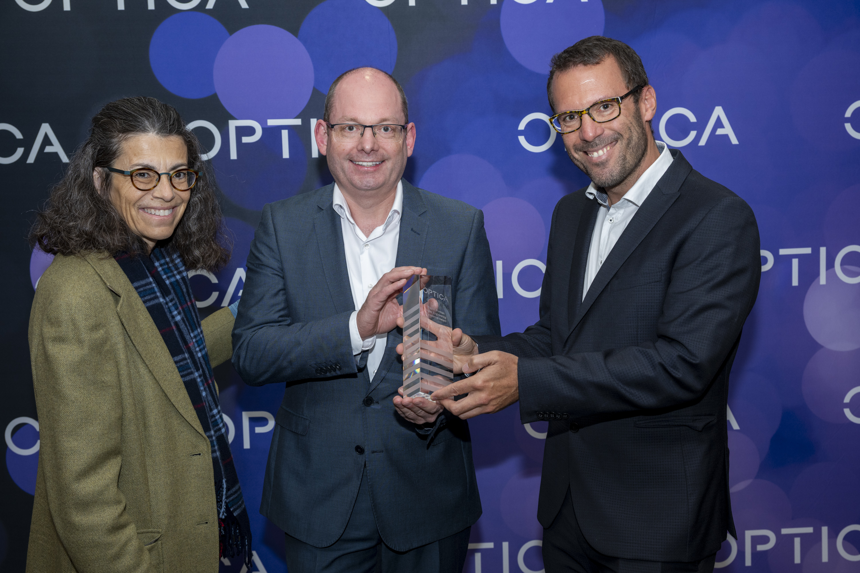 Optica President Gisele Bennett presents the award to Stephan Ritter and Axel Friedenauer on behalf of the TOPTICLOCK Team. Photo: Laurence L. Levin/Optica