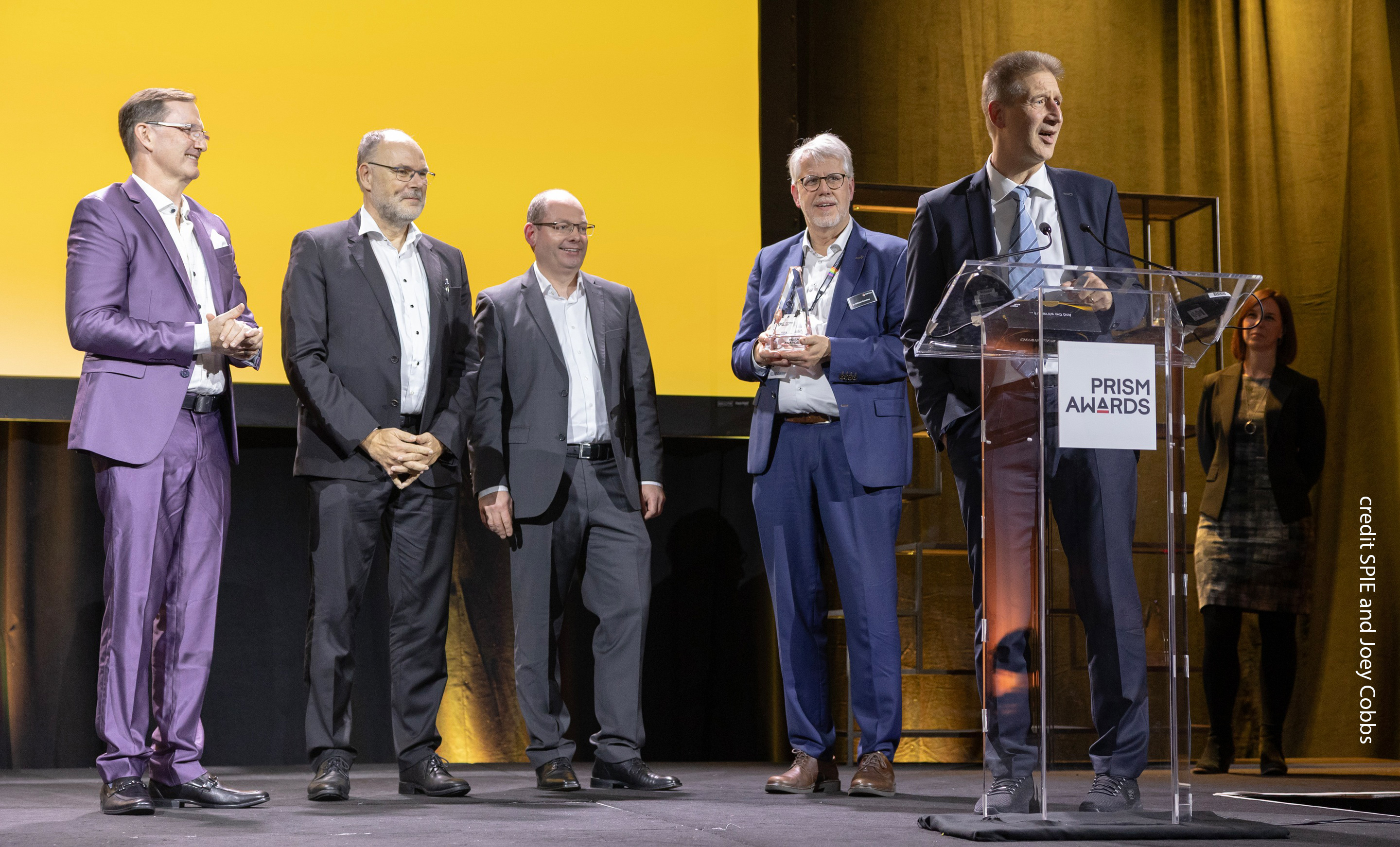 Pictured from left to right: Mark Tolbert (CEO, TOPTICA Photonics, Inc.), Dr. Thomas Renner (President & CSO), Dr. Stephan Ritter (Senior Director Quantum Technology Solutions), Dr. Wilhelm Kaenders (President, Founder & CTO), and Dr. Jürgen Stuhler (VP Quantum Technologies, speaking).  📸 Credit: SPIE and Joey Cobbs